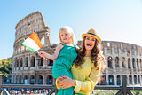 Smiling mother holding daughter with Italian flag and Colosseum