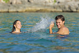 Couple playing bathing on the beach in summer vacation