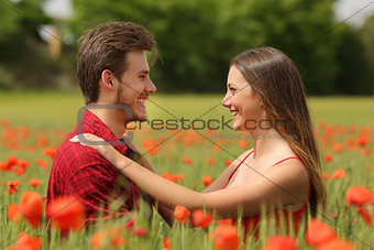 Couple looking each other affectionate in a red field