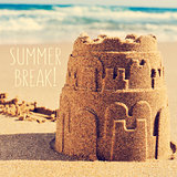 sandcastle on a beach and the text summer break