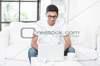 Indian guy using computer at home.