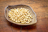 bowl of pine nuts on rustic wood