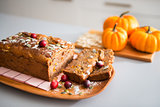 Closeup of home-made, sliced fruit and nut loaf and mini pumpkin