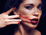 beauty brunette woman under black veil with red manicure close up
