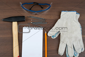 Welding goggles with note pad and nails on table