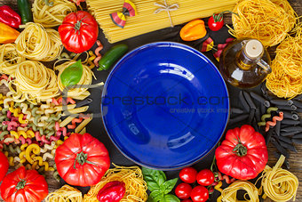 Raw pasta with ingridients and blue plate