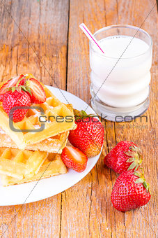 homemade waffles with strawberries maple syrup