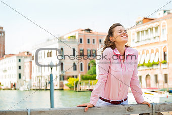 Happy woman smiling up to the sun in Venice