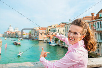 Laughing woman tourist in Venice framing shot of Grand Canal