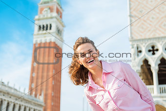 Happy woman tourist with St. Mark's bell tower and Doge's Palace