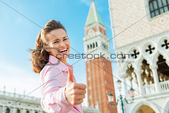 Happy woman tourist giving thumbs up on St. Mark's Square