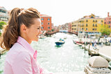 Smiling woman in profile in Venice standing above canal