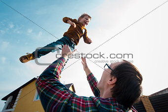 man throws the boy in the sky