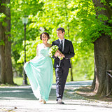 Wedding couple walking in park.