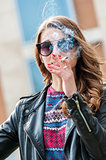 Beautiful female smoking a cigarette with smoke in front of face.
