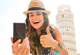 Happy woman tourist giving thumbs up taking selfie in Pisa
