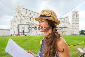 Happy female tourist in profile holding map, Piazza dei Miracoli