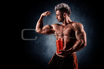 young handsome man with strong muscles, protein drink after trai