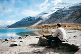 A couple resting in front of a mountainous lake