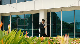 Businessman Chatting On Mobile Phone Walking To Office