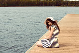 romantic girl on jetty near lake  