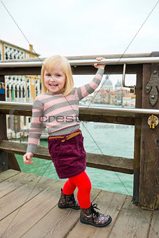 Happy, smiling blonde girl on bridge in Venice