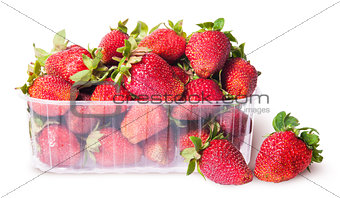 Freshly strawberries in a plastic tray and two near