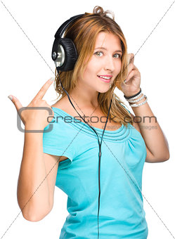 music and technology concept - young woman listening to music and show on her headphones, isolated on white 