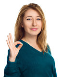 Young woman is showing OK sign, isolated over white 