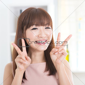 Asian girl showing v hands sign