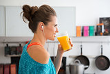 Closeup of fit woman in profile starting to drink smoothie