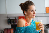 Closeup of woman in profile wearing workout gear holding juice