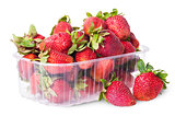 Freshly strawberries in a plastic tray and two near rotated