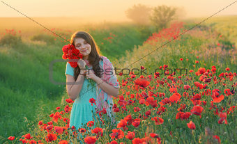 Girl stands in poppy field