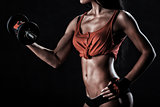 Brutal athletic woman pumping up muscles with dumbbells
