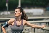 Woman runner taking a break in the sunshine listening to music