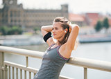 Woman leaning back with hands behind head, relaxing on bridge