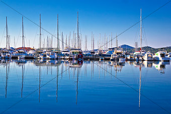 Sailboats and yachts in harbor reflections view