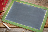 blank slate blackboard with chalk and books
