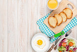 Healthy breakfast with fried egg, toasts and salad