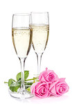 Two champagne glasses and pink rose flowers