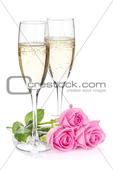 Two champagne glasses and pink rose flowers