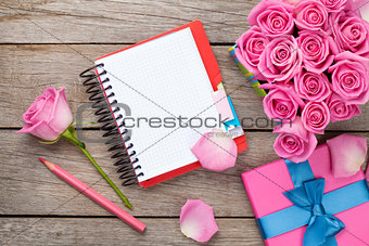 Blank notepad and gift box full of pink roses
