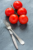 Ripe tomatoes and cutlery.