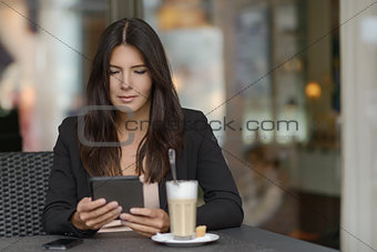 Woman relaxing in a coffee bar with her mobile