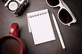 Notepad, glasses, pen and cup on the table