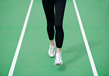 Woman Athlete Runner Feet Running on Green Running Track. Fitness and Workout Wellness Concept.