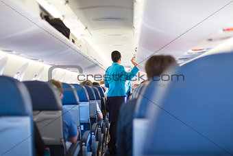 Interior of airplane with passengers on seats.