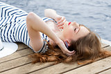 girl relaxing on jetty near sea 
