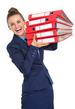 Smiling woman holding stack of files up in the air and laughing